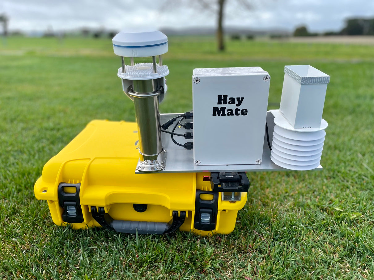 HayMate Max with wind, rainfall, temperature and humidity sensors beside its yellow case